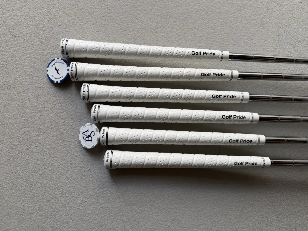 Finished clubs with white Golf Pride grips ready to return