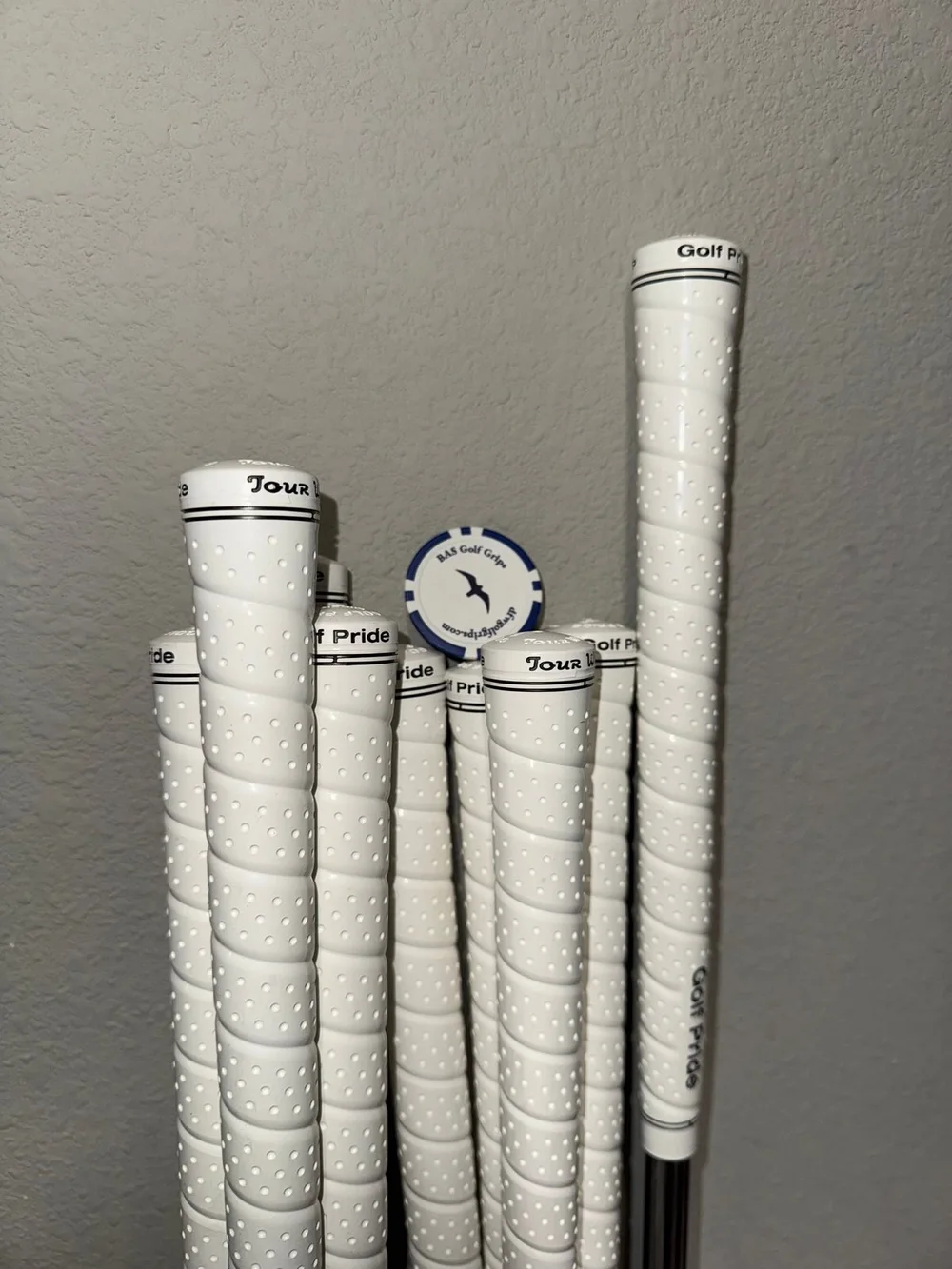 Completed white wrap-style golf grip installation on a full club set