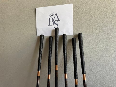 Set of black makeup brushes with rose gold ferrules displayed with ABA logo card holder